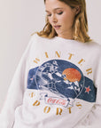 Front view of woman wearing Chaser’s white Coca-Cola Winter Sports Long Sleeve with vintage-inspired graphic design on a plain background
