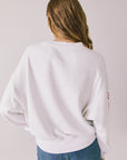Back view of woman wearing Chaser’s white Coca-Cola Winter Sports Long Sleeve on a plain background