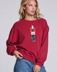 Model wearing Chaser's Coca-Cola Holiday Coke Pullover in Winter Garnet red with vintage Coca-Cola bottle artwork, angled view