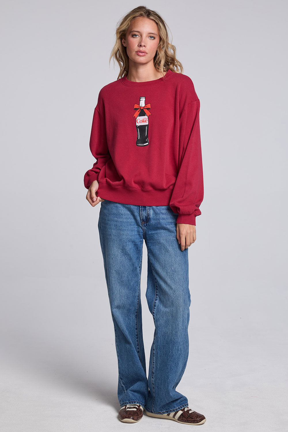 Model wearing Chaser's Coca-Cola Holiday Coke Pullover in Winter Garnet red with vintage Coca-Cola bottle artwork, full-body view