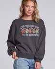 Model wearing Chaser's Grateful Dead 'Tis the Season Pullover in Fresh Gravel with colorful Grateful Dead holiday artwork, angled view