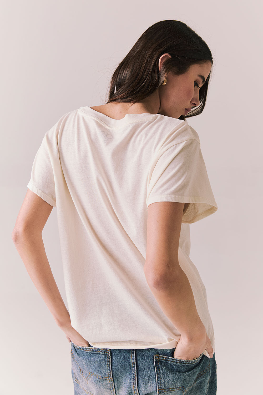 Back view of model wearing the Jackson Hole Sunset Tee in white with scenic Western graphic with graphic design on a plain background