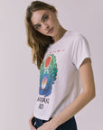 Side view of a woman wearing Chaser's white Journey 1980 Tour Tee with a colorful graphic design on a plain background