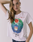 Front view of a woman wearing Chaser's white Journey 1980 Tour Tee with a colorful graphic design on a plain background
