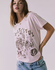 3/4 view of a woman wearing Chaser's the Grateful Dead 60 Years so Far pink tee with a graphic design on a plain background