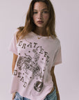 Front view of a woman wearing Chaser's the Grateful Dead 60 Years so Far pink tee with a graphic design on a plain background