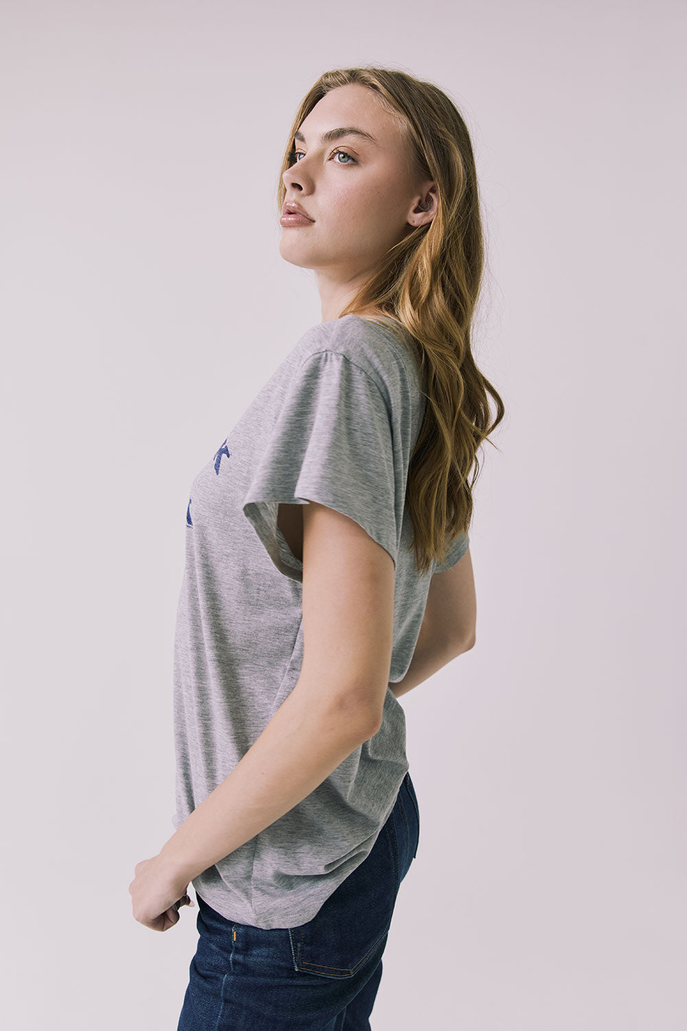 Side view of the Chaser Woodstock 1969 New York Tee in Heather Grey showing a relaxed fit and soft drape through the sleeve