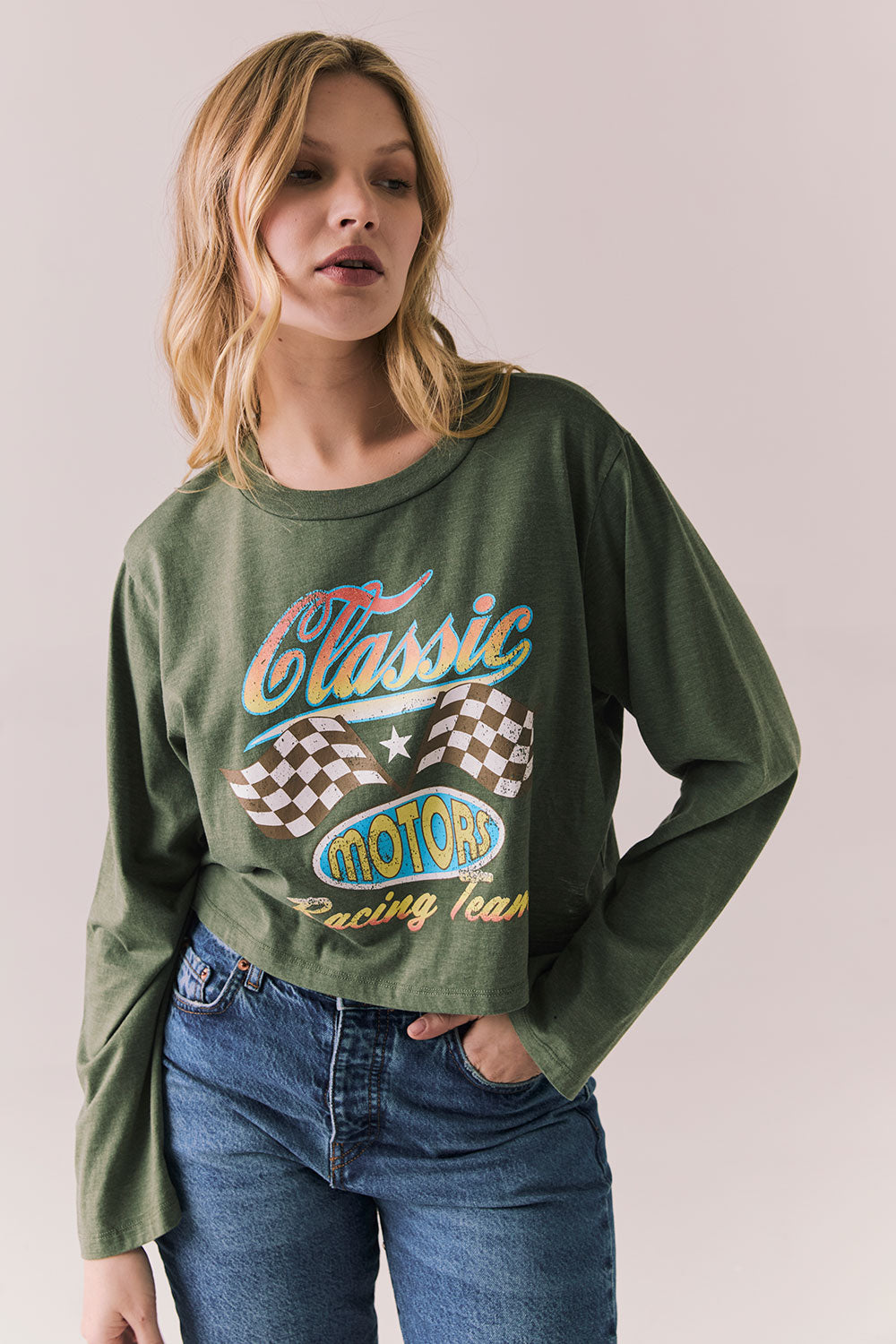 Front view of womens wearing Chaser's Classics Motors washed bronze green long sleeve with retro graphic on a plain background
