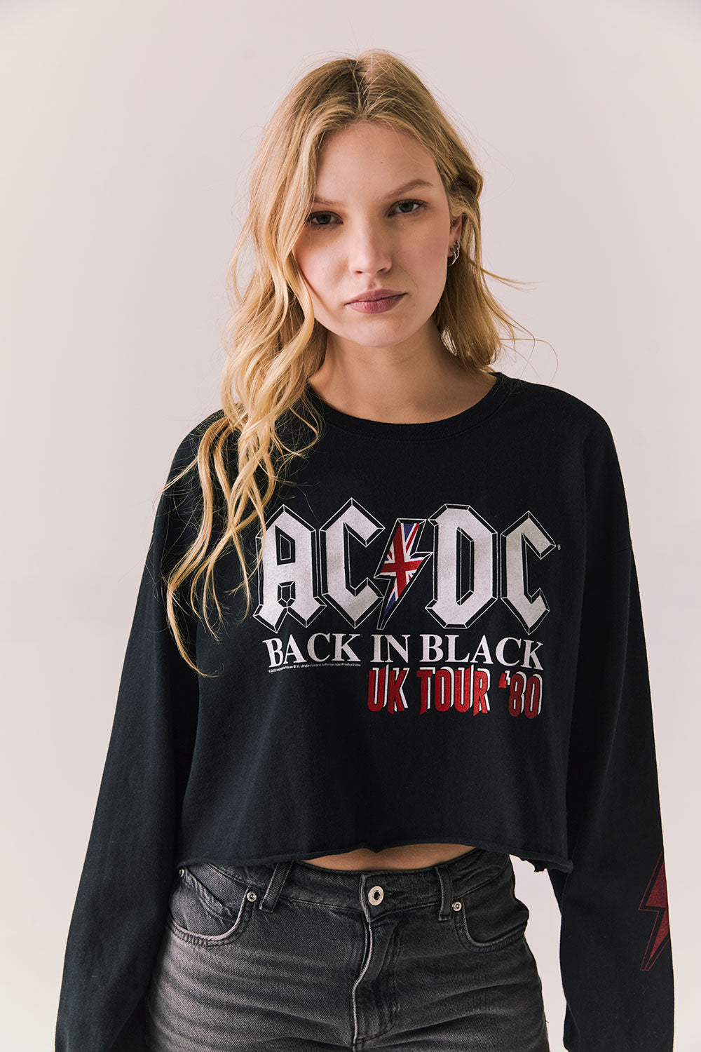 Front view of AC/DC UK Tour ’80 Tee in True Black with vintage UK Tour 1980 poster graphic and cropped long-sleeve fit on plain background