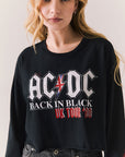 Front view of AC/DC UK Tour ’80 Tee in True Black with vintage UK Tour 1980 poster graphic and cropped long-sleeve fit on plain background