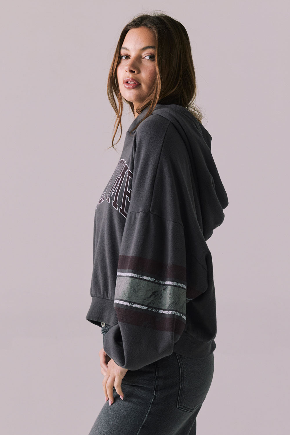 Side view of model wearing the Halftime fleece pullover hoodie in True Black with ‘HALFTIME’ chest graphic, against a plain background.