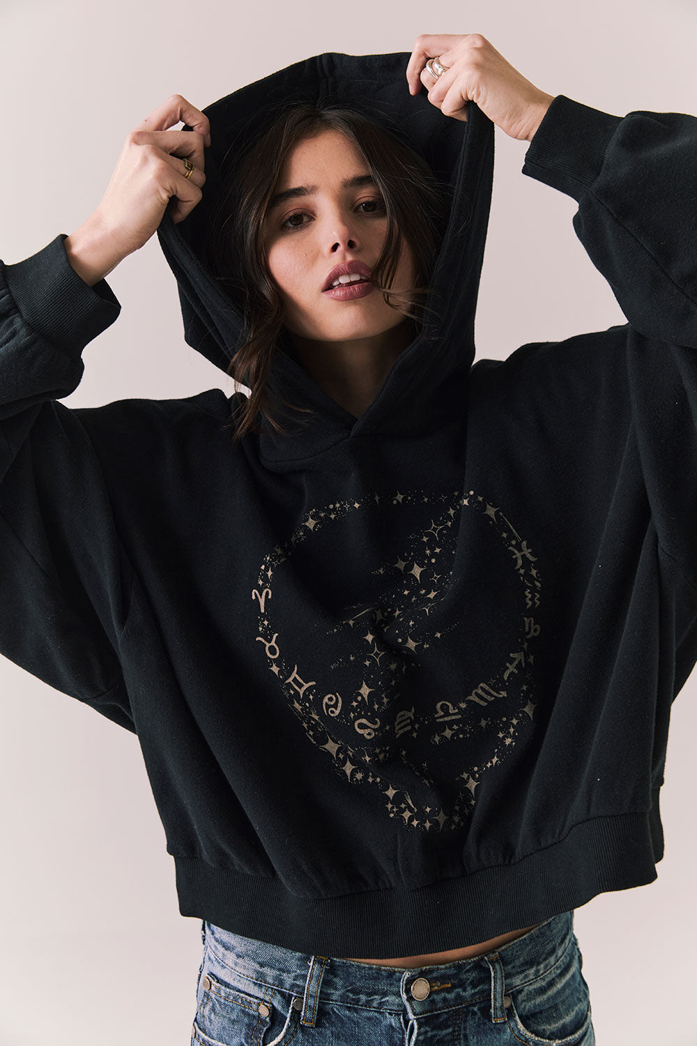 Front view of The Grateful Dead We Are Everywhere Hoodie in True Black with cropped boxy fit, hood up, and skull graphic made from stars and zodiac signs against a plain background
