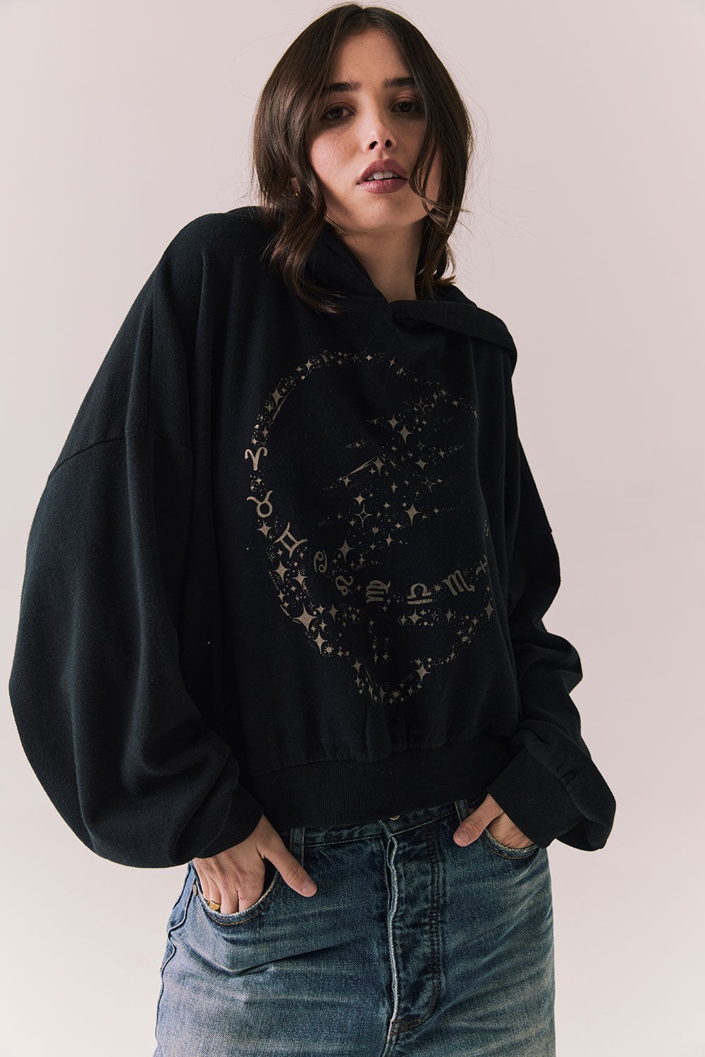 Side view of The Grateful Dead We Are Everywhere Hoodie in True Black with cropped boxy fit and skull graphic made from stars and zodiac signs against a plain background