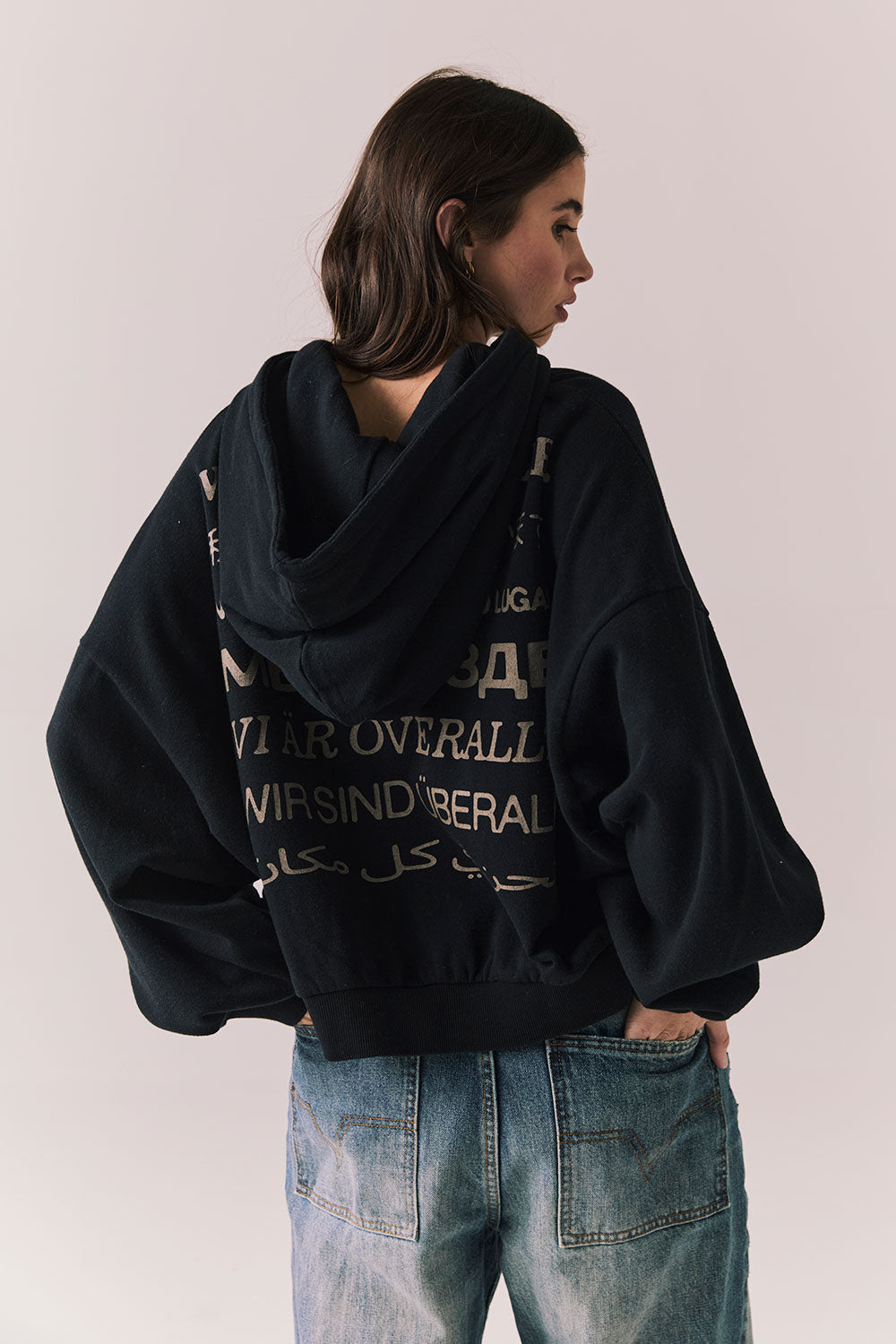 Back view of The Grateful Dead We Are Everywhere Hoodie in True Black with cropped boxy fit and skull graphic made from stars and zodiac signs against a plain background