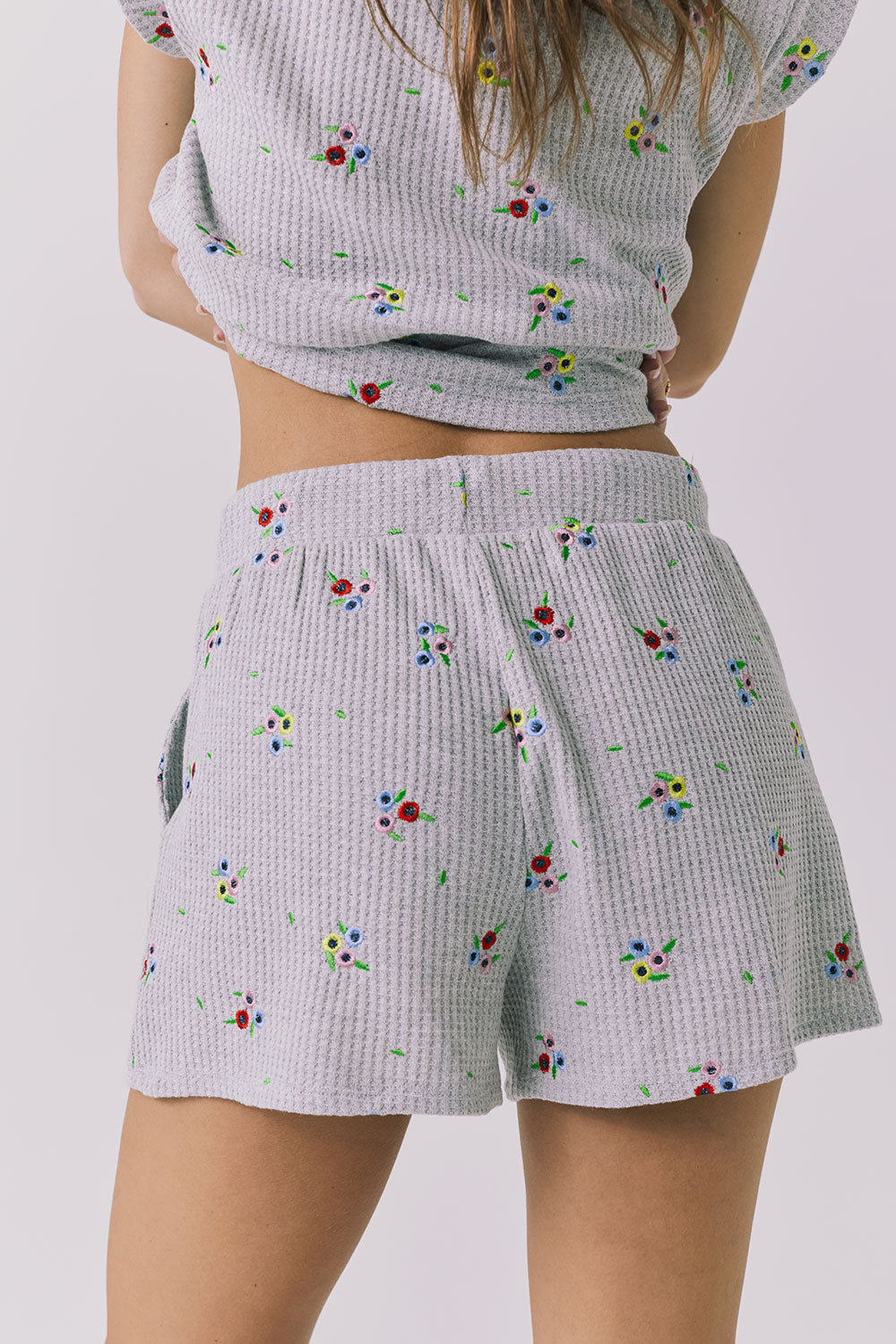 Chaser Kesh Short in Heather Grey with ditsy embroidery shown from the back featuring a relaxed silhouette elastic waistband and allover embroidered floral pattern