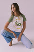 Chaser Road To Nowhere USA Tee in Stray White Meadow Green shown in a relaxed kneeling pose with the vintage Route 66 graphic visible