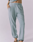 Front view of woman wearing Chaser's Mission Joggers in garden green sage on a plain background