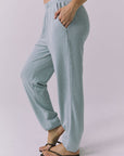 Side view of woman wearing Chaser's Mission Joggers in garden green sage on a plain background