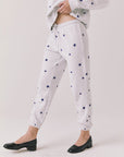 Side view of woman wearing Chaser’s Festive Stars Joggers in light grey with star patterns on a white background