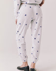 Back view of woman wearing Chaser’s Festive Stars Joggers in light grey with star patterns on a white background
