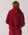 Back view of woman wearing Chaser’s Hazen Purple-Red Fig Pullover Hoodie on a white background