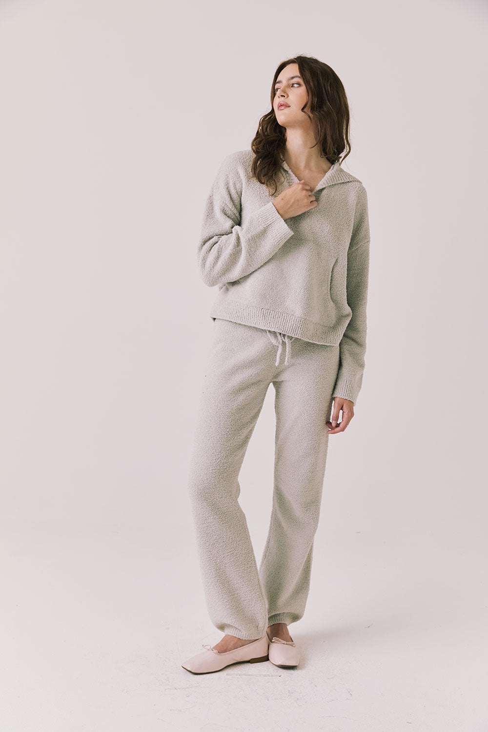Full body view of woman wearing Chaser’s Hazen Heather Grey Pullover hoodie with matching Monica Heather Grey Joggers on a white background