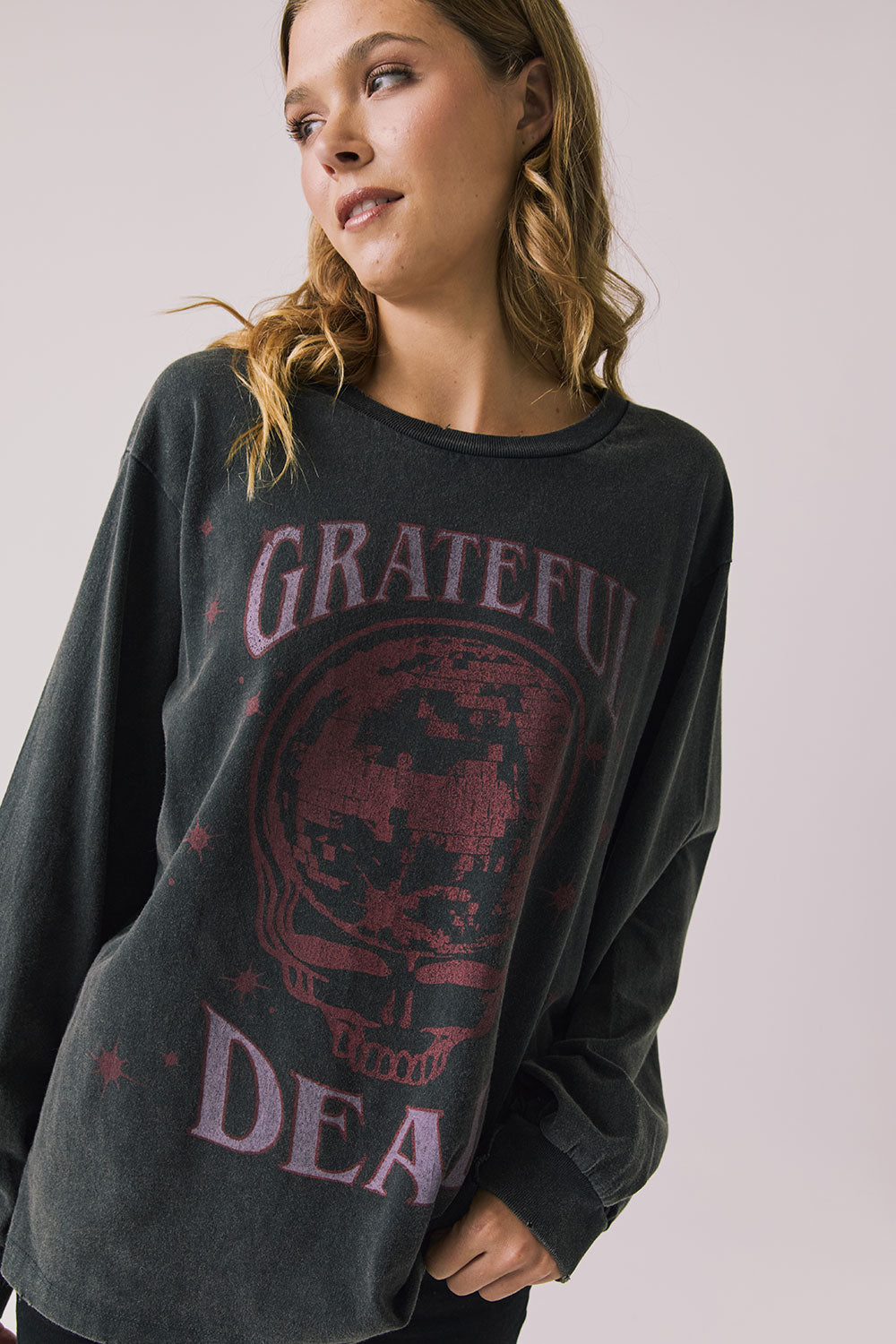 Front view of woman wearing Chaser’s Grateful Dead Disco Stealie Long Sleeve with a skull design on a plain background