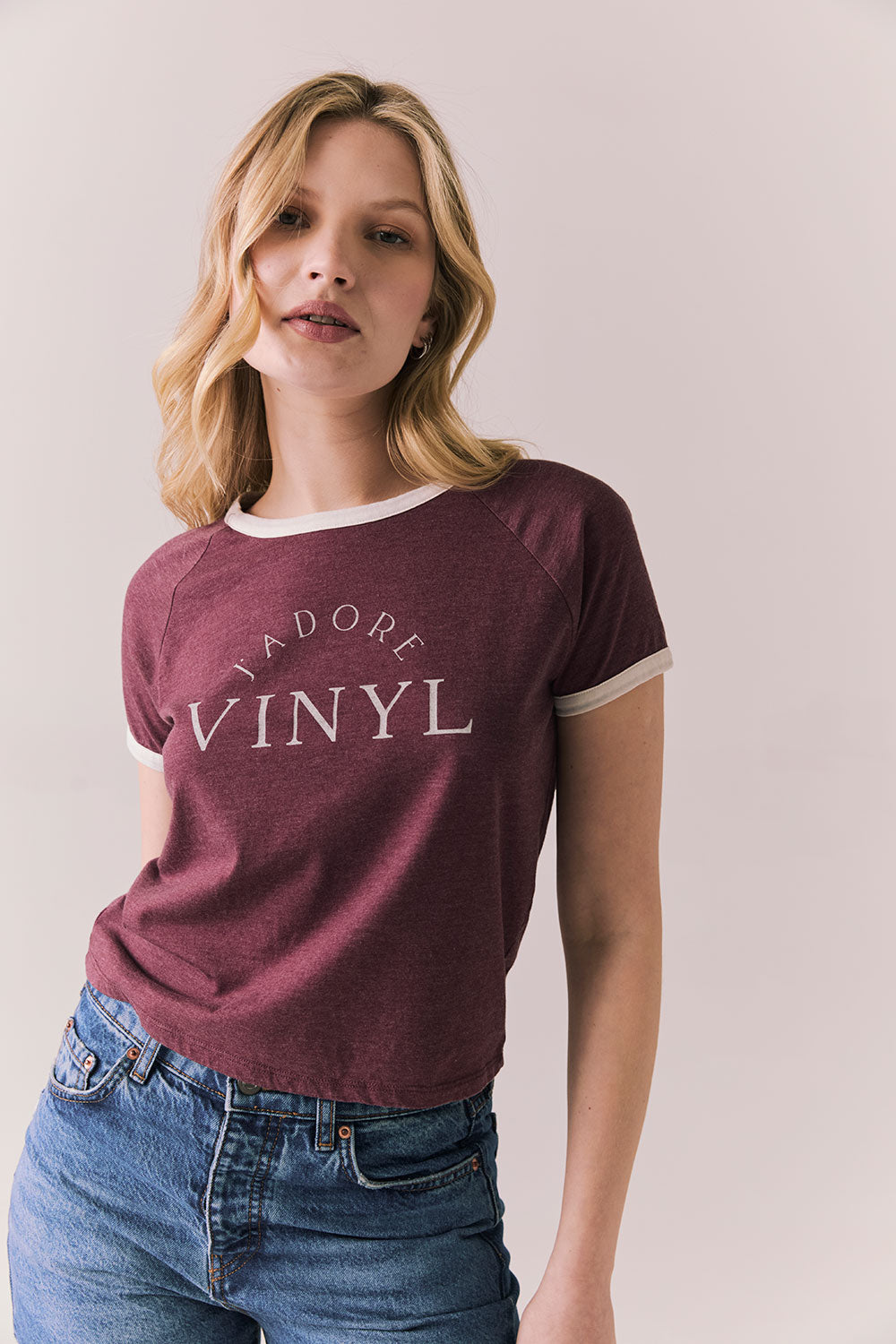 Front view of model in J’adore Vinyl Tee in fig purple with cream ringer trim and vintage-style text