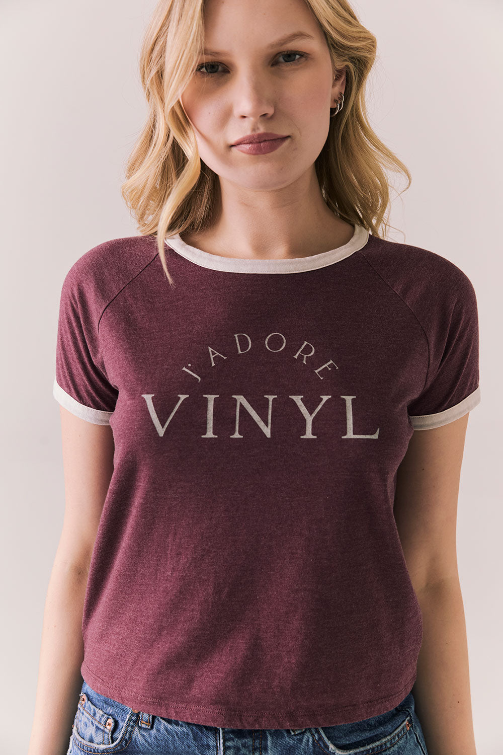 Front view of model in J’adore Vinyl Tee in fig purple with cream ringer trim and vintage-style text