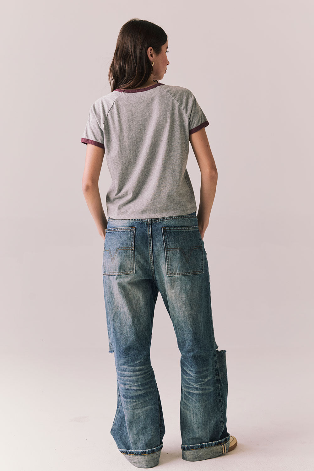  Back body view of model in Coca-Cola heather grey ringer tee and denim