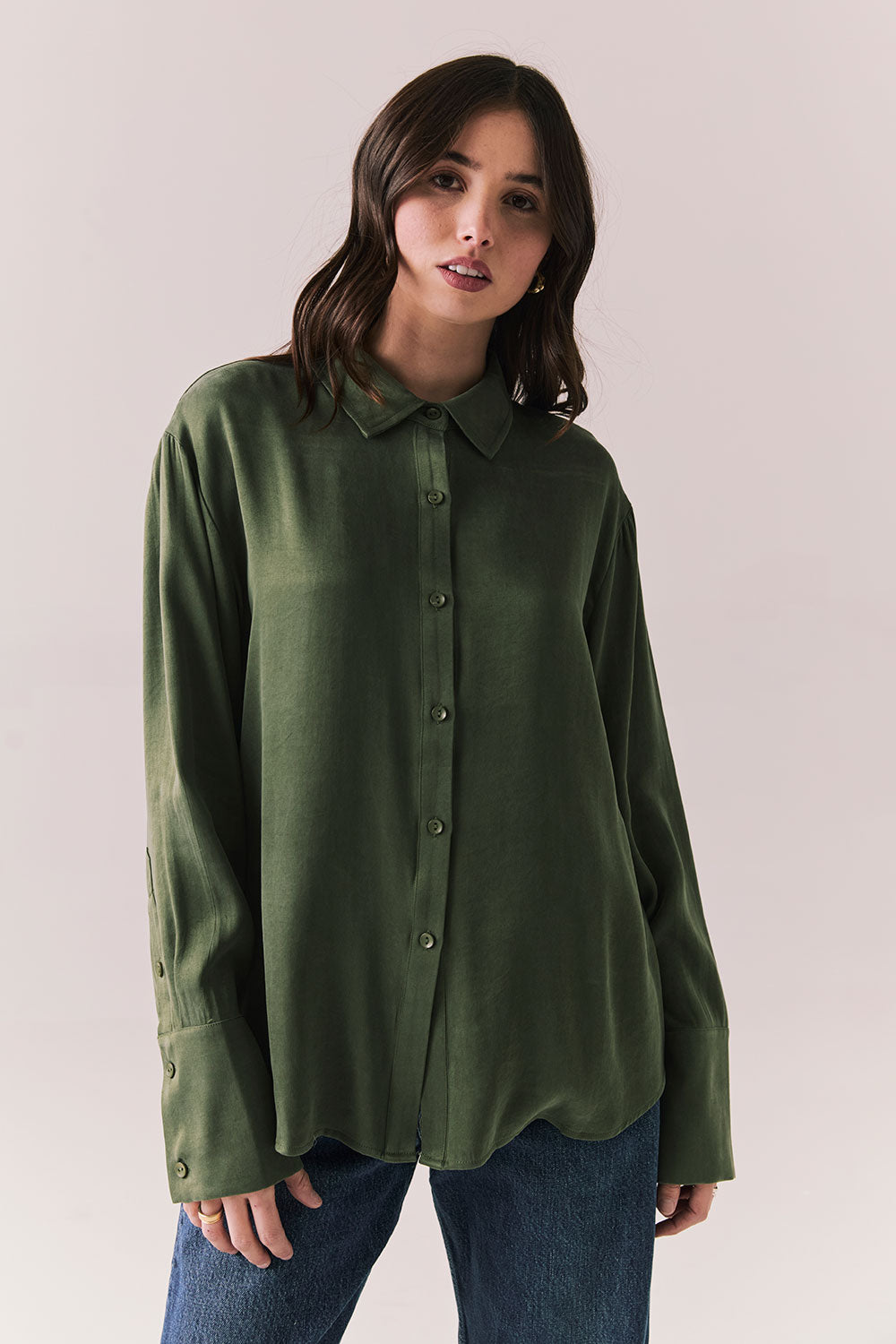 Front view of a model wearing the Helenaa button-down shirt in bronze green with collared neckline and relaxed silhouette,  against a plain background.