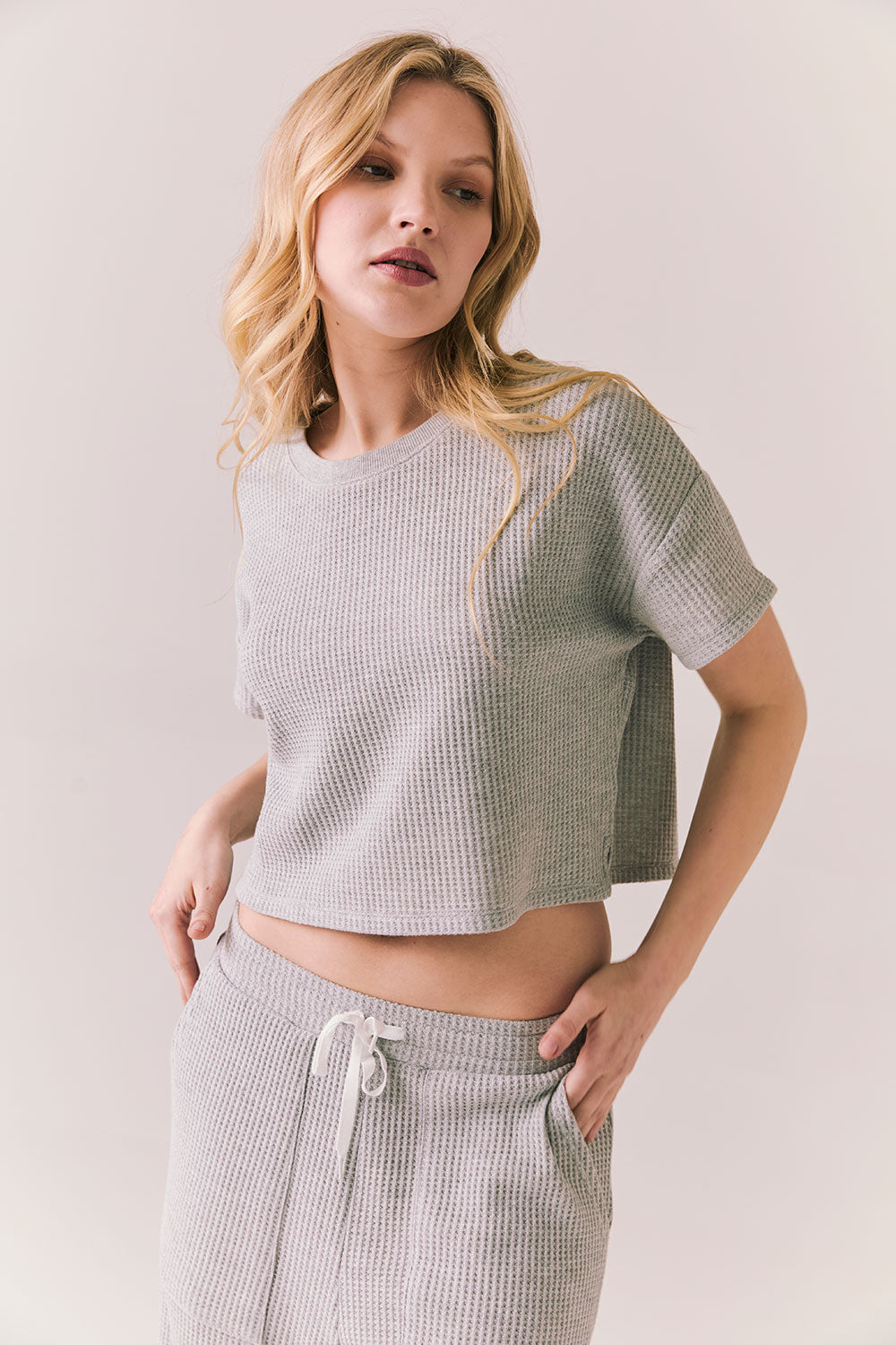 3/4 view of model in Irvine Tee in heather grey with soft thermal texture against a plain background