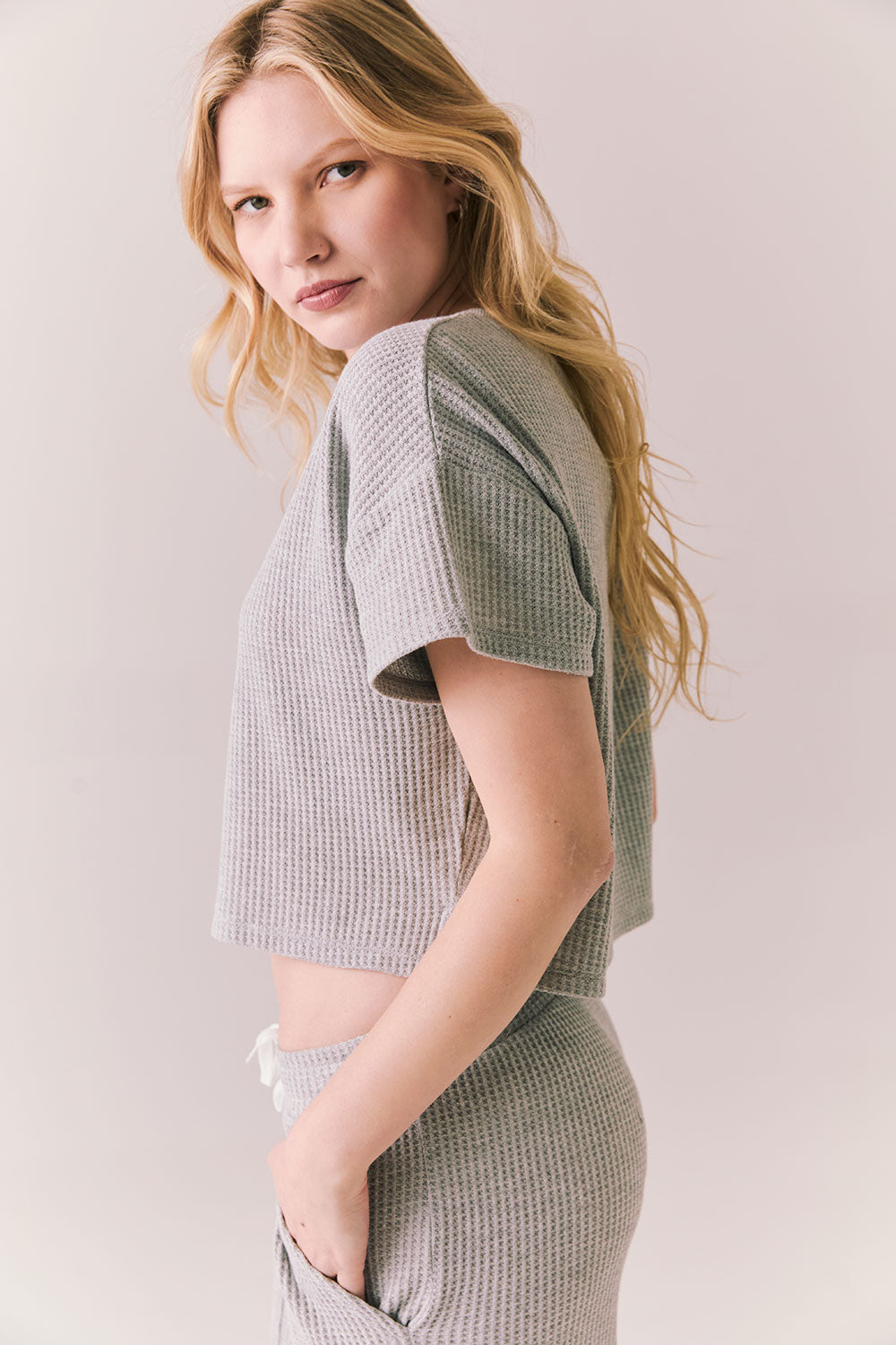 Side view of model in Irvine Tee in heather grey with soft thermal texture against a plain background