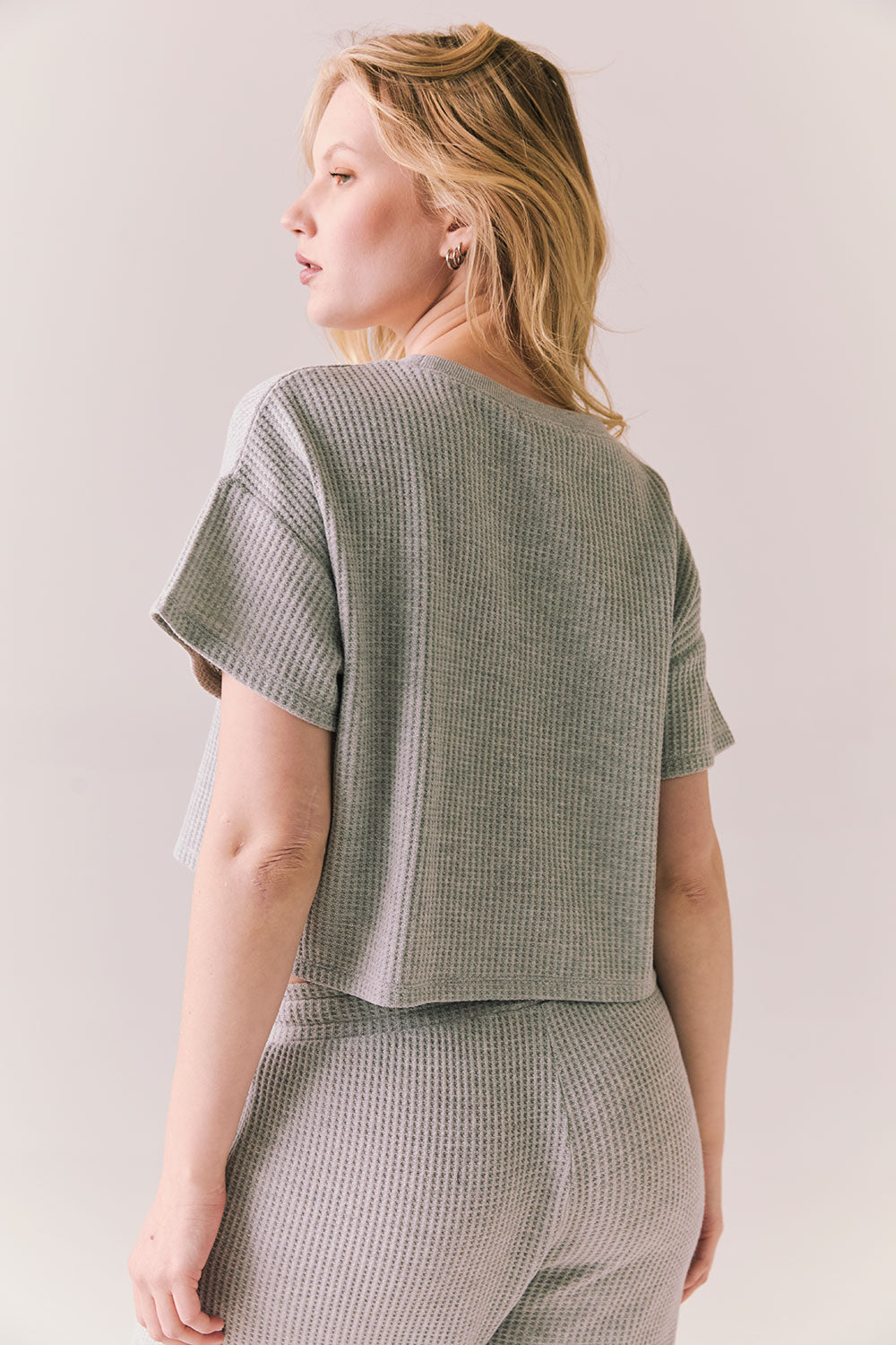 Back view of model in Irvine Tee in heather grey with soft thermal texture against a plain background