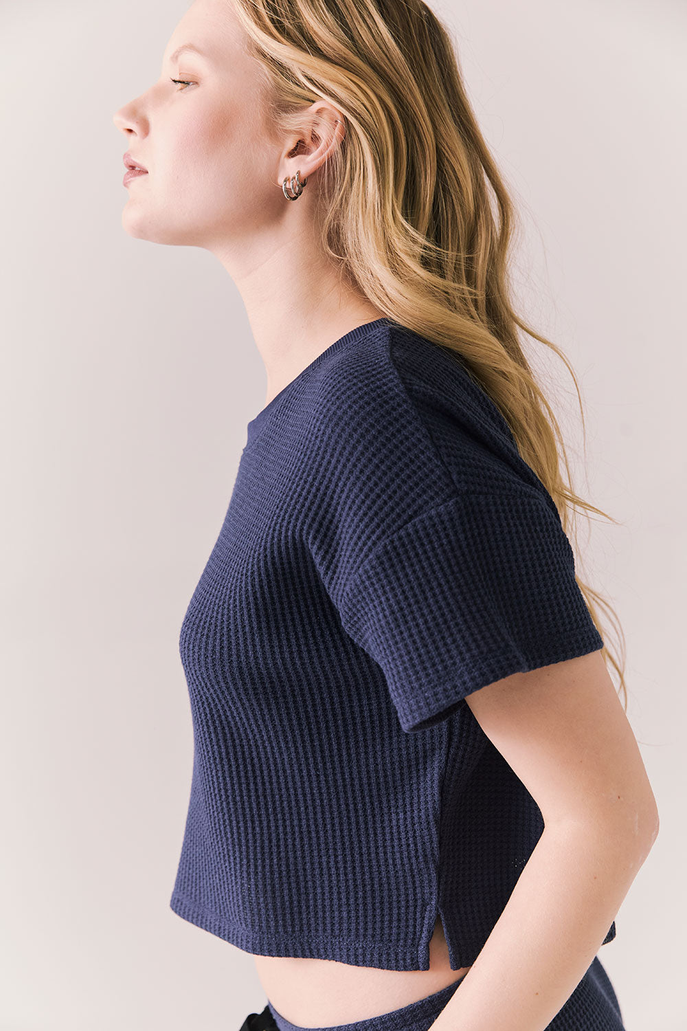 Side view of model in Irvine Tee in midnight blue with soft thermal texture on plain background