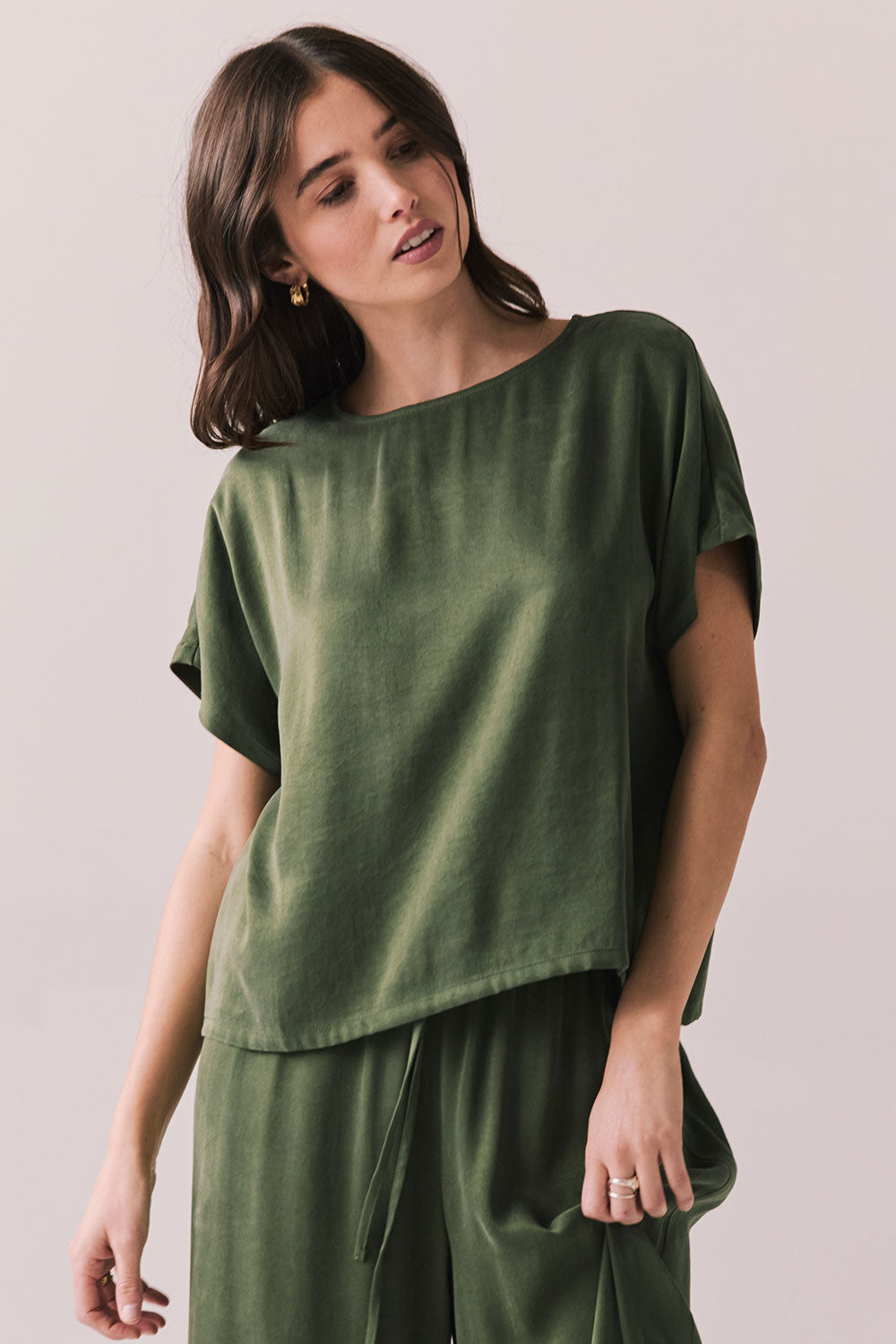 Woman wearing the Davis tee in bronze green against a plain background