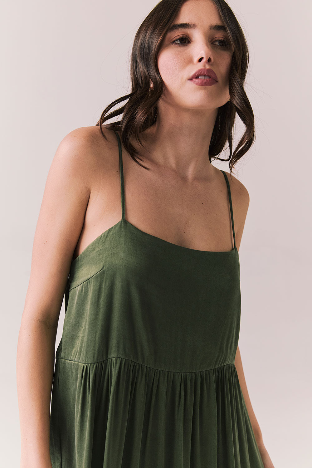 Close up of woman wearing the Berkeley Maxi Flowy Silky Dress in Green against a white background