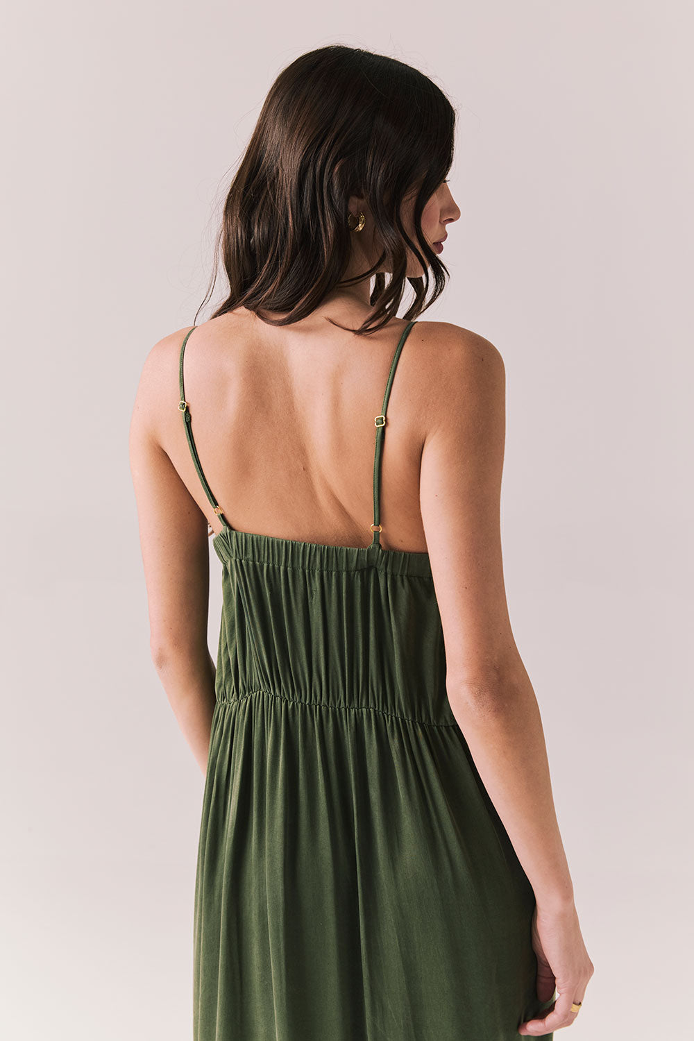 Closeup back of woman wearing the Berkeley Maxi Flowy Silky Dress in Green against a white background