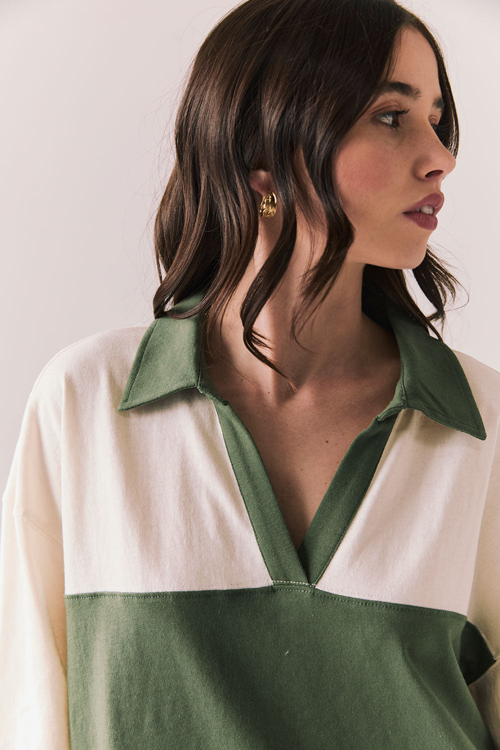 Close up of woman wearing the color-blocked Chico Long Sleeve White and Green Rib Pullover on a white background