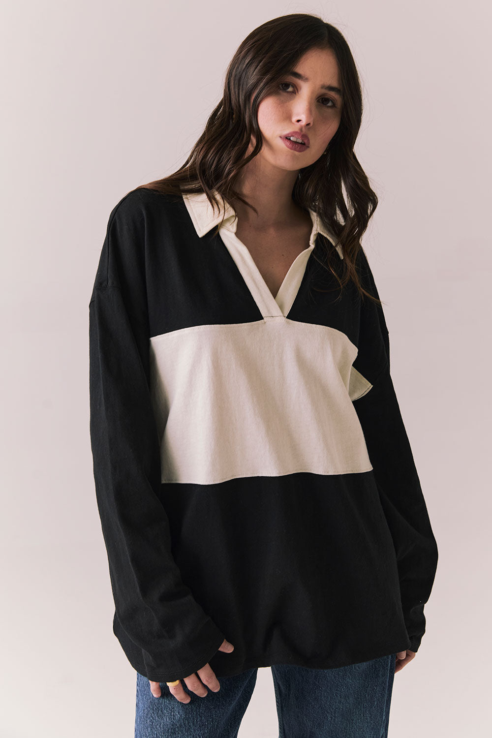 Front view of woman wearing a black and white Chico long sleeve with striped design against a plain background