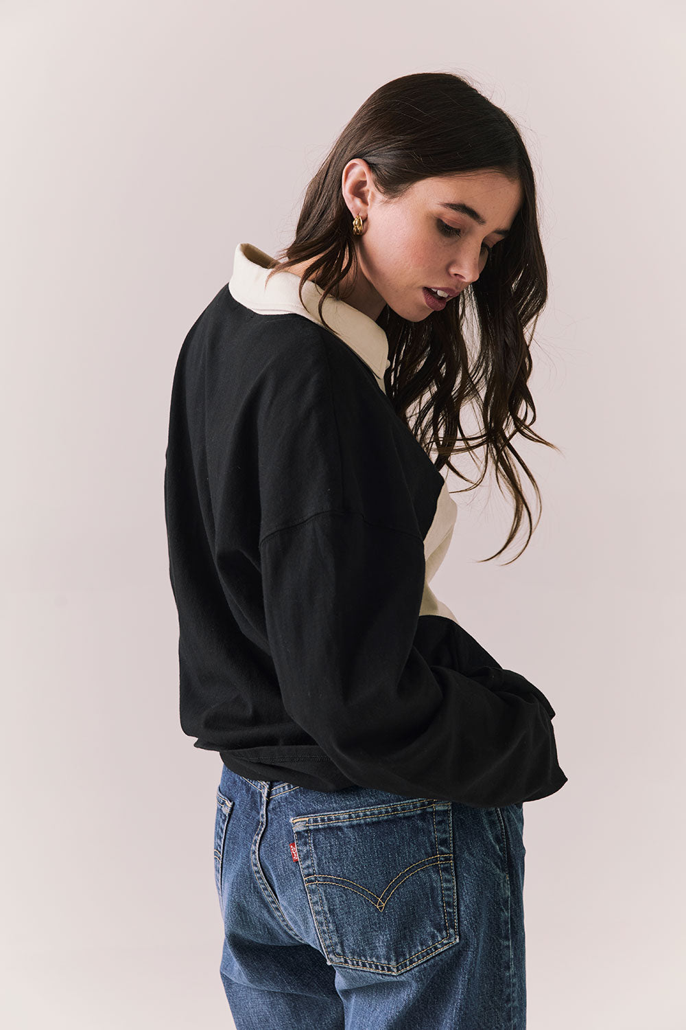 Back view of woman wearing a black and white Chico long sleeve with striped design against a plain background