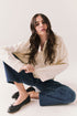 Woman sitting on the floor wearing the Humboldt long sleeve in starry white with soft cotton texture and blue jeans against a white background