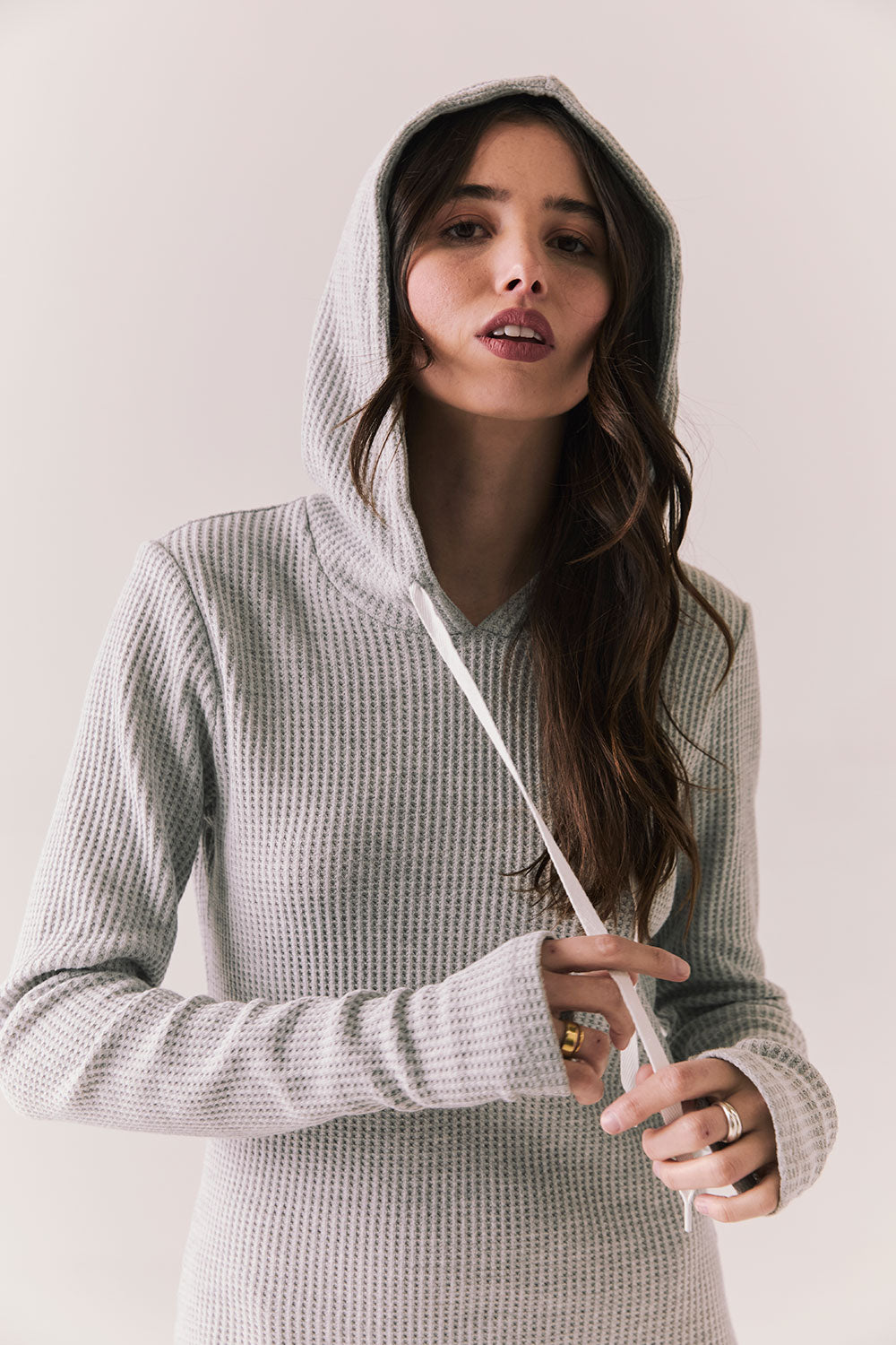 Front view of model wearing Merced Hoodie Dress in Heather Grey with hood and thermal knit texture against a plain background
