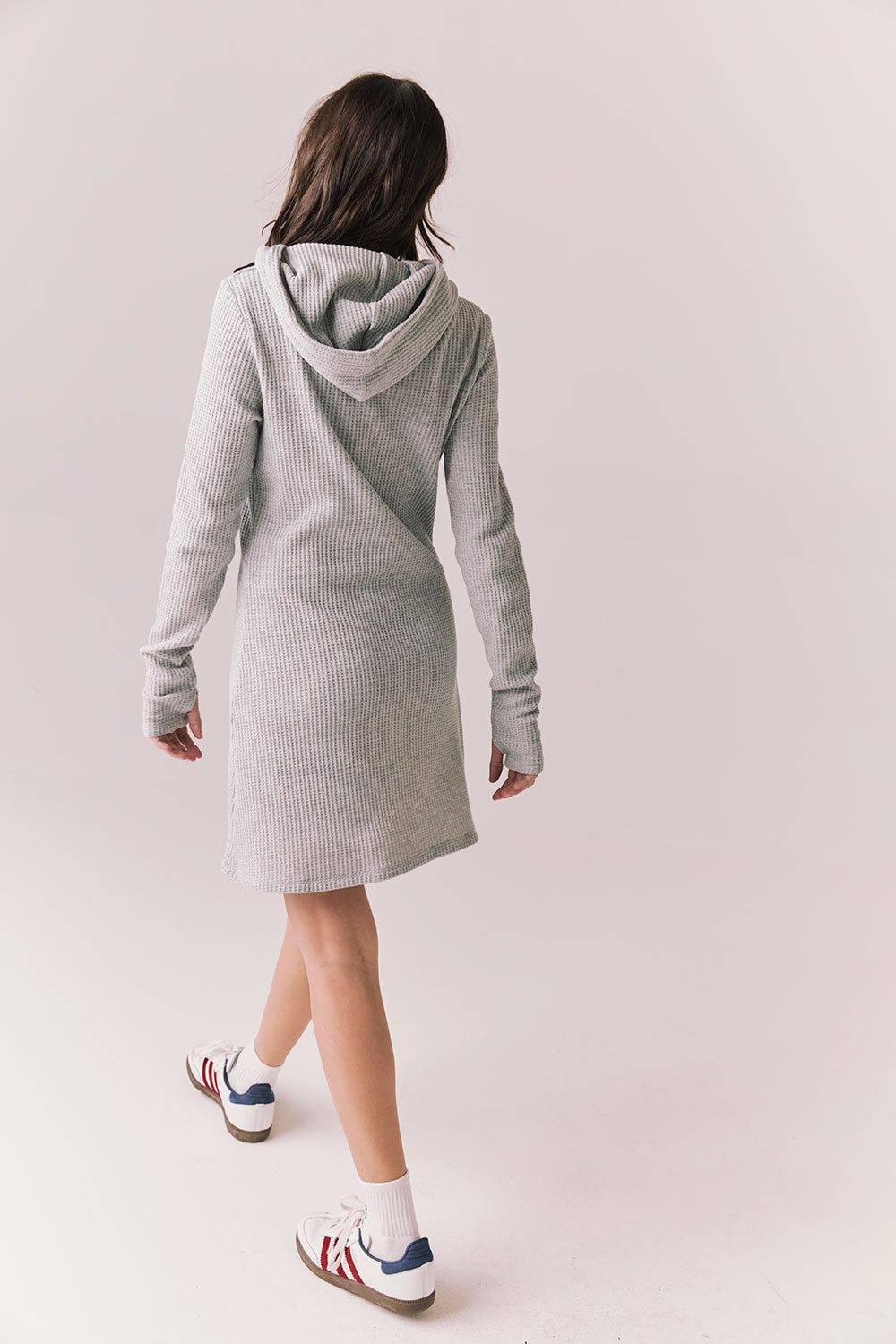 Full back view of model wearing Merced Hoodie Dress in Heather Grey with hood and thermal knit texture against a plain background
