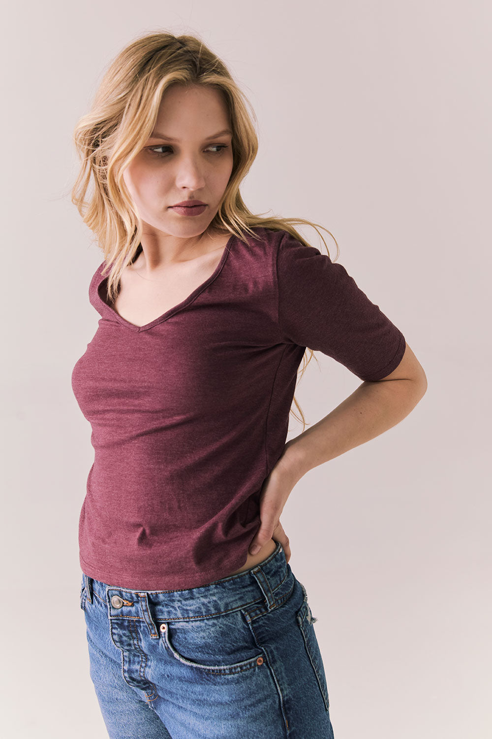 Side view of Fresno tee in fig with scoop neck and fitted silhouette on a plain background