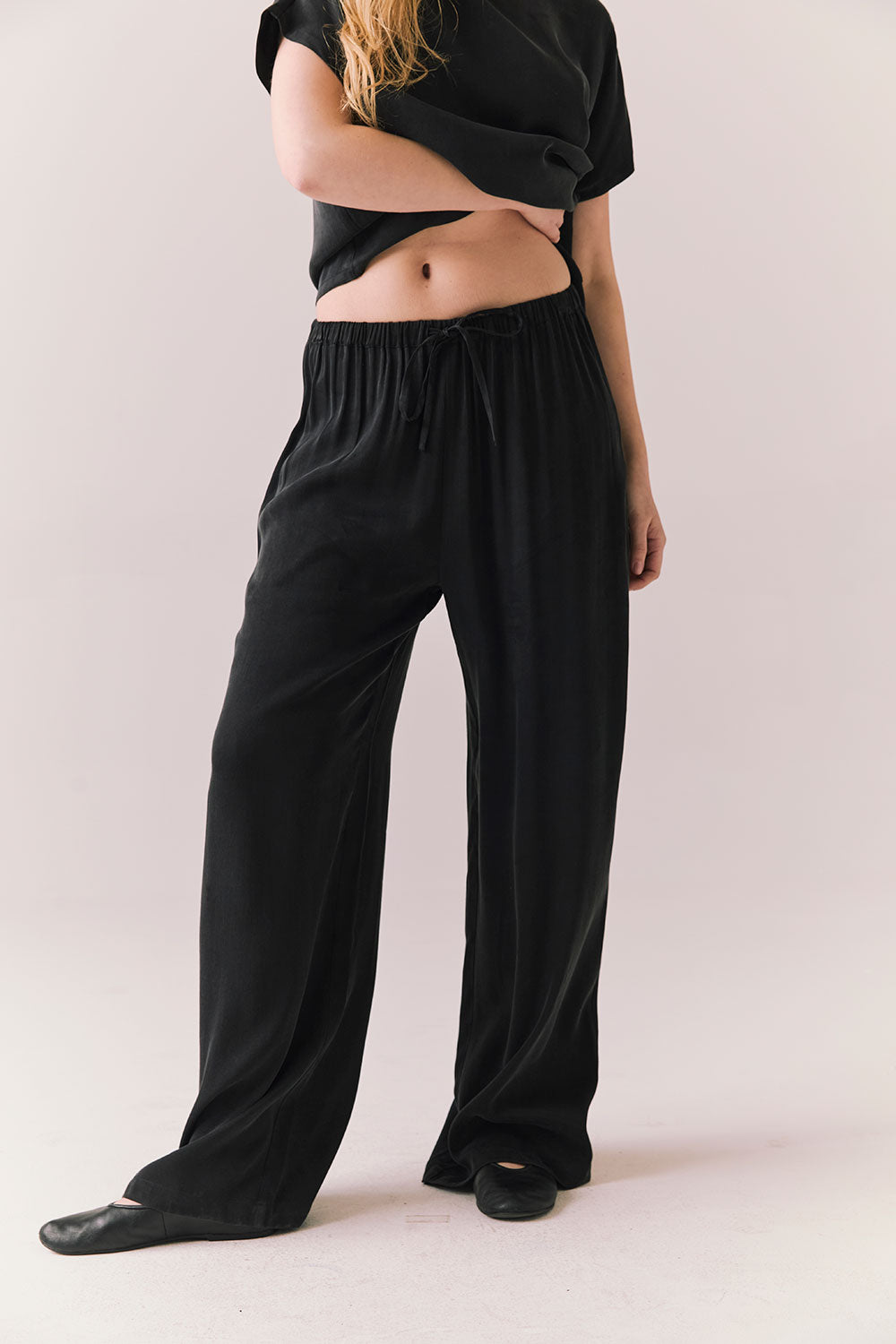 Front view of model wearing Lee Trouser in True Black with high-rise fit and wide-leg silhouette with matching Davis top against a plain background
