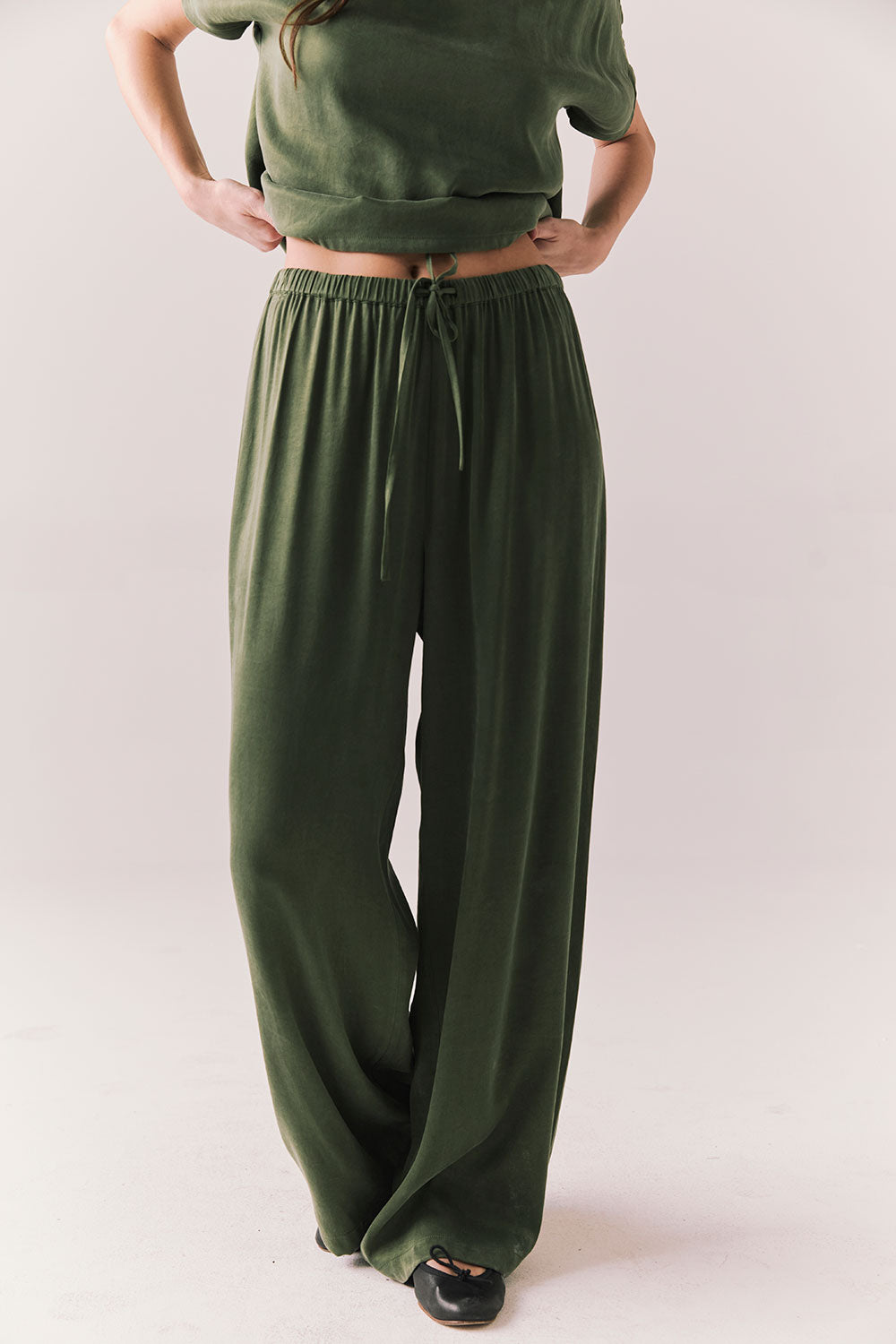 Front view of Lee Trouser in bronze green with wide-leg silhouette and relaxed drape against a plain background