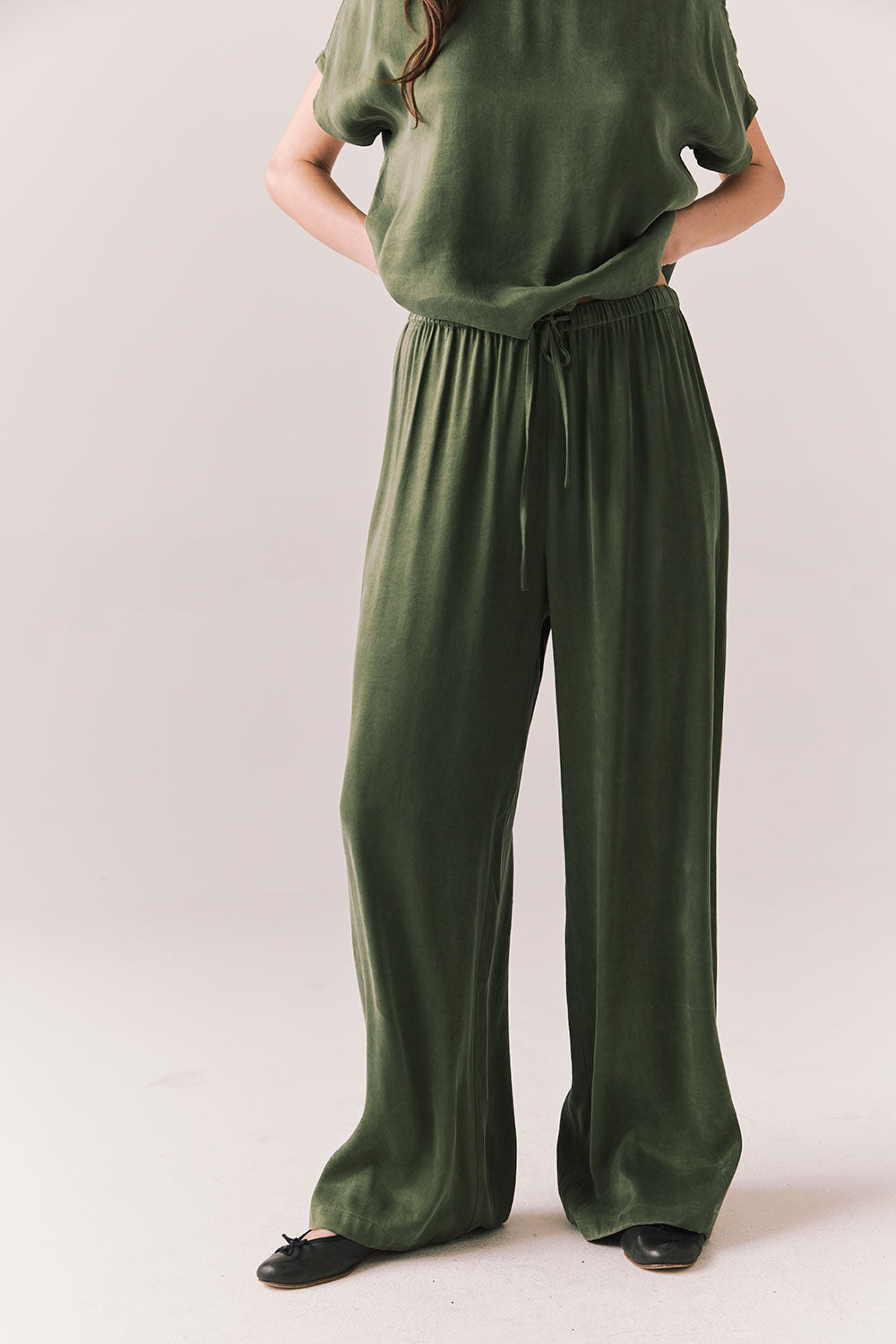 Front view of Lee Trouser in bronze green with wide-leg silhouette and relaxed drape against a plain background