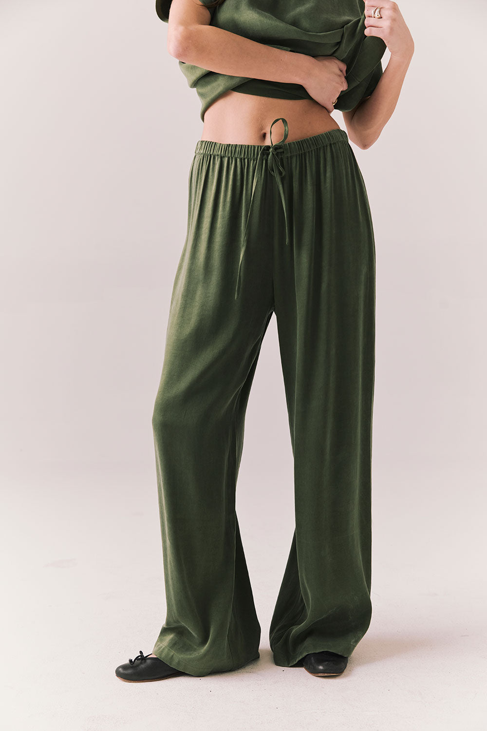 Front view of Lee Trouser in bronze green with wide-leg silhouette and relaxed drape against a plain background