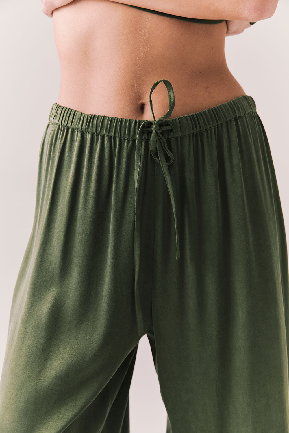 Closeup view of Lee Trouser drawstring in bronze green with wide-leg silhouette and relaxed drape against a plain background 